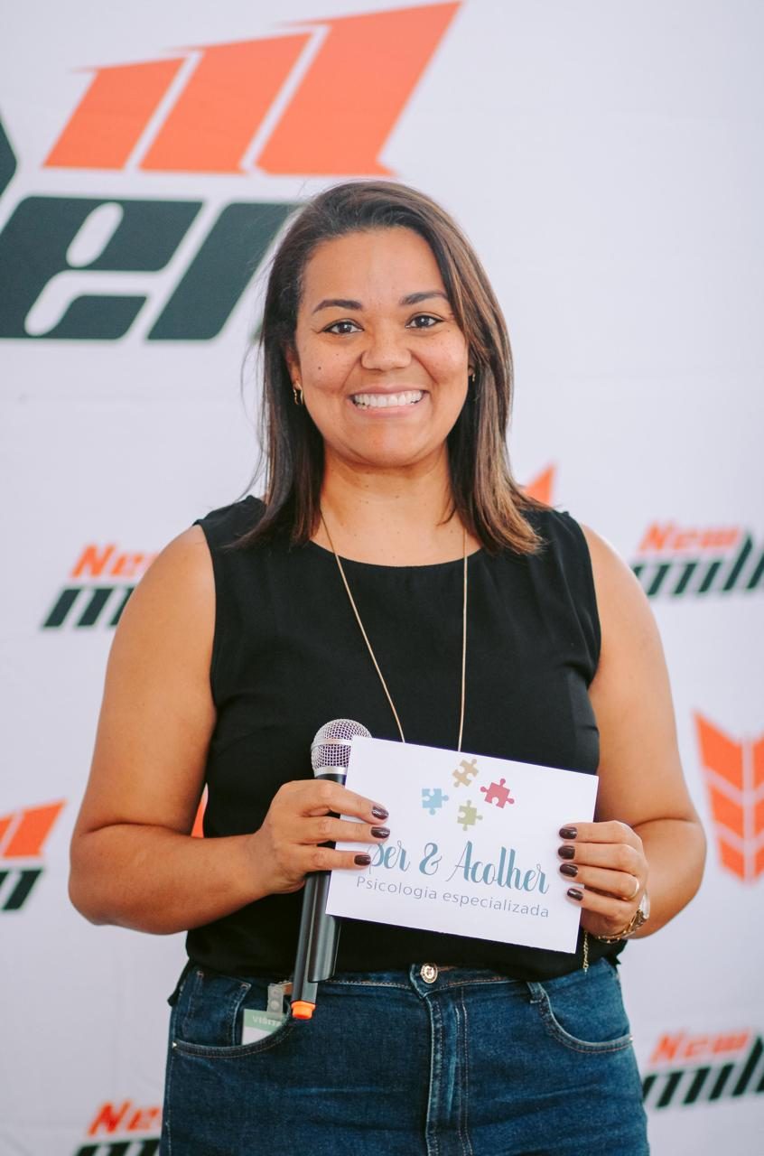 Adriana Satu com microfone durante uma palestra corporativa